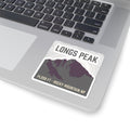 Longs Peak sticker applied to the corner of an open silver laptop beside the keyboard
