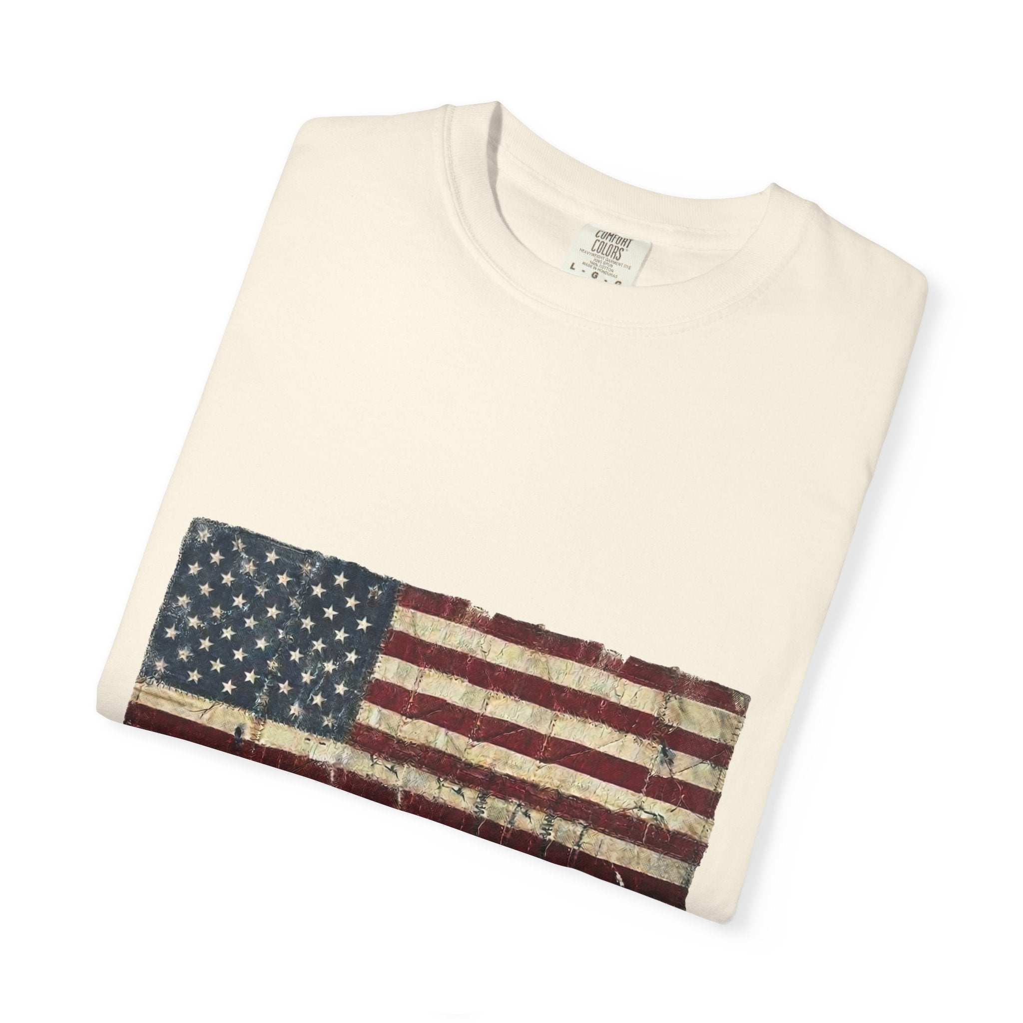 Distressed tattered US flag with HOME OF THE BRAVE lettering on a garment-dyed Comfort Colors vintage tee