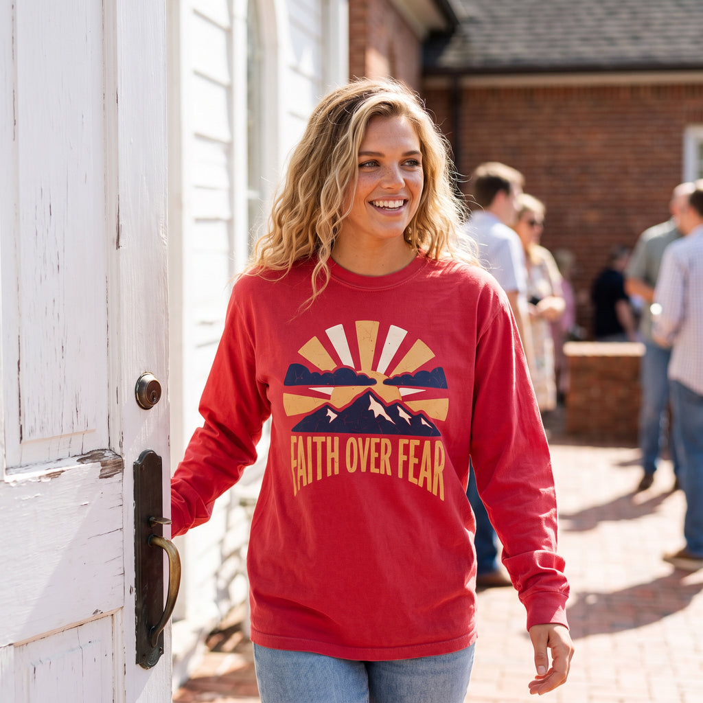 Faith Over Fear long sleeve tee in red, worn by an approved model, mid lifestyle photograph