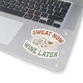 Sweat Now Wine Later sticker applied to the corner of an open silver laptop beside the keyboard