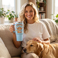 Professional Dog Cuddler 15oz insulated mug in light blue, held by an approved model, wide lifestyle photograph