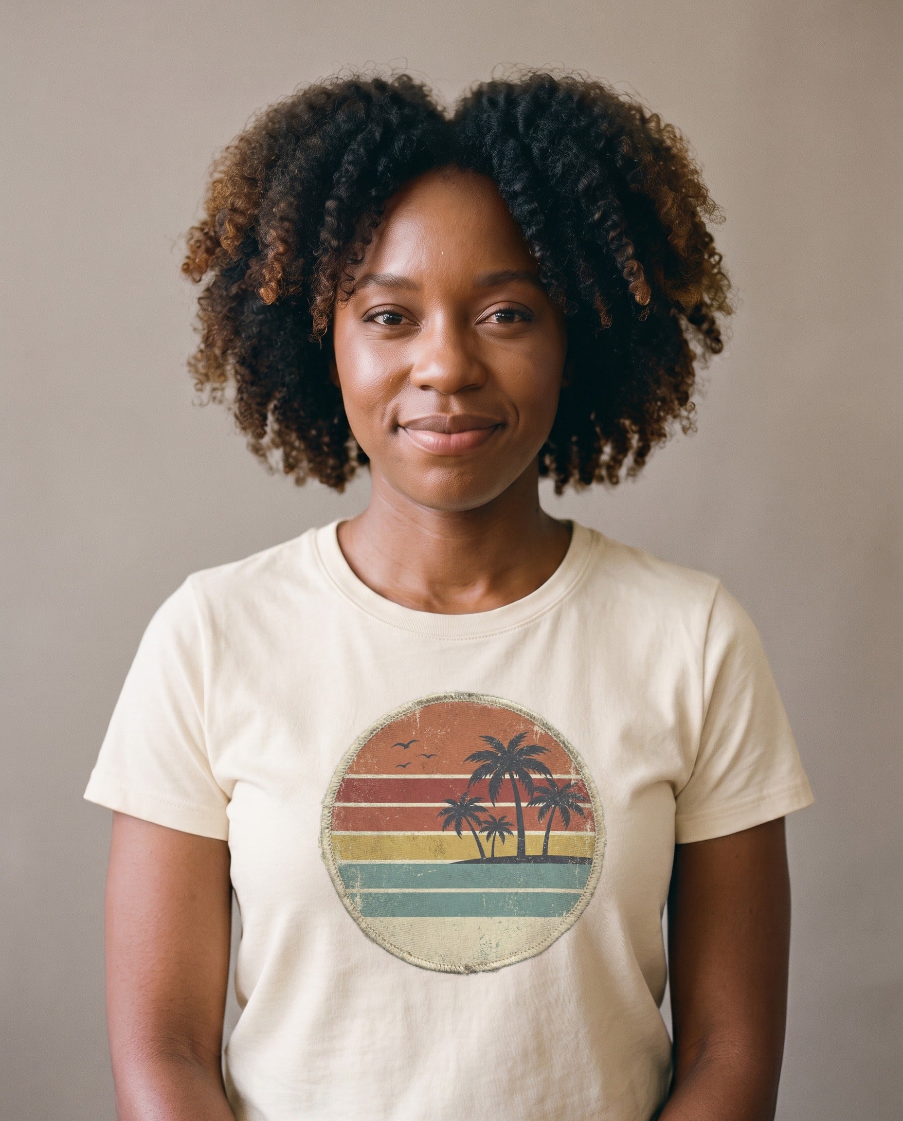 Woman wearing the Retro Sunset Circle badge tee in Natural, vintage circle badge with palms and striped sunset