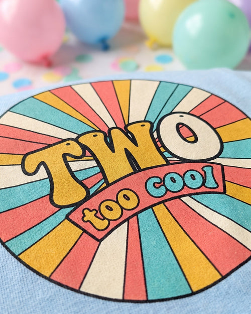 Close up of the Two Too Cool 2nd birthday retro sunburst print showing soft matte ink on cotton weave
