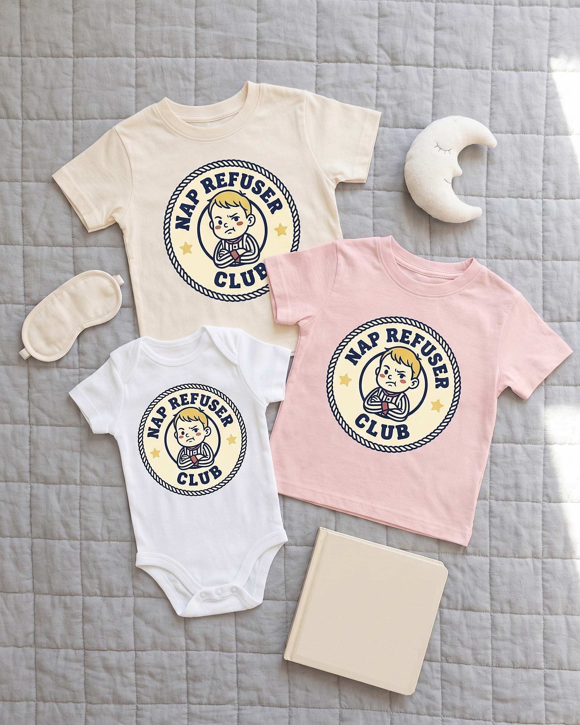 Flat lay of the Nap Refuser Club badge design across matching kids garments with playful props