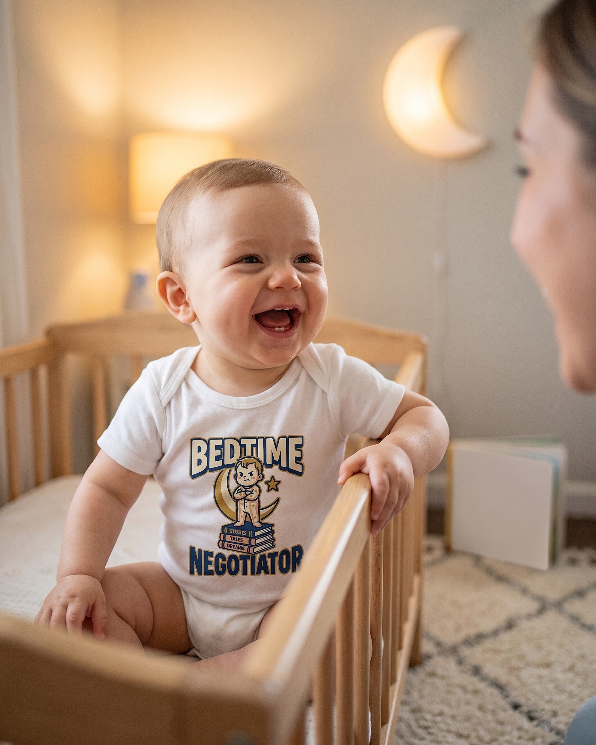 Bedtime Negotiator design on a white baby bodysuit worn by a happy baby