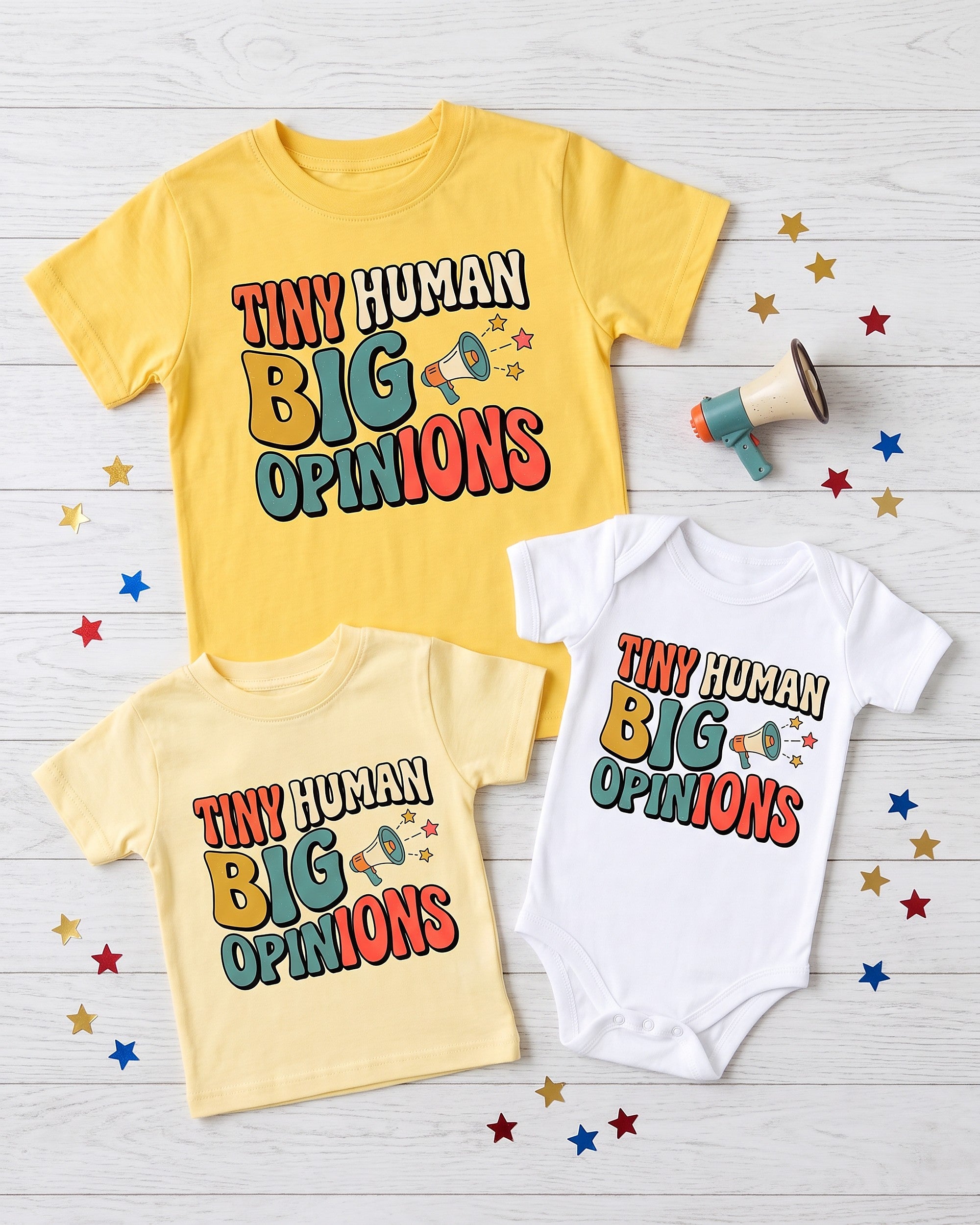Flat lay of the Tiny Human Big Opinions design across matching kids garments with playful props