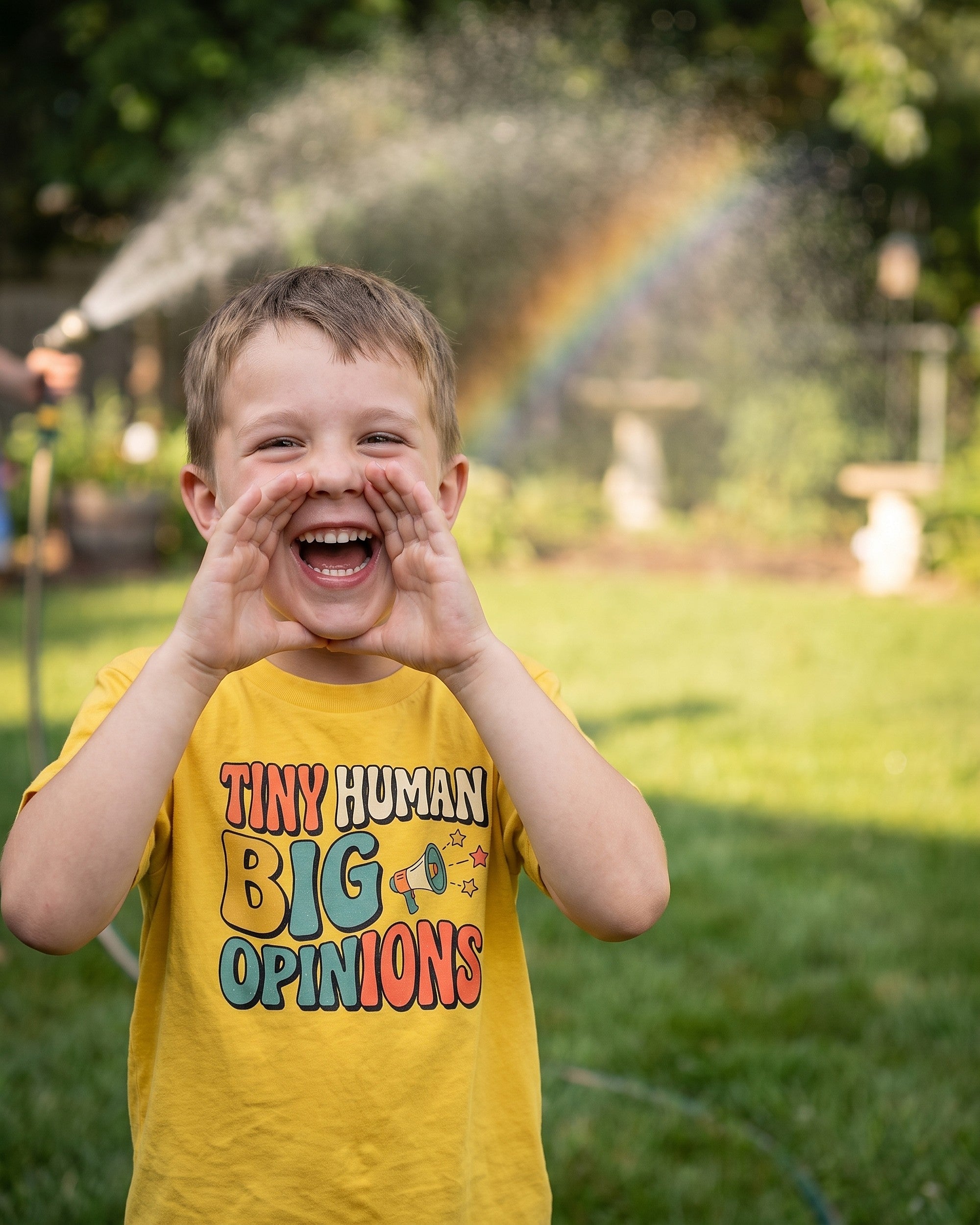 Tiny Human Big Opinions design worn by a smiling child outdoors