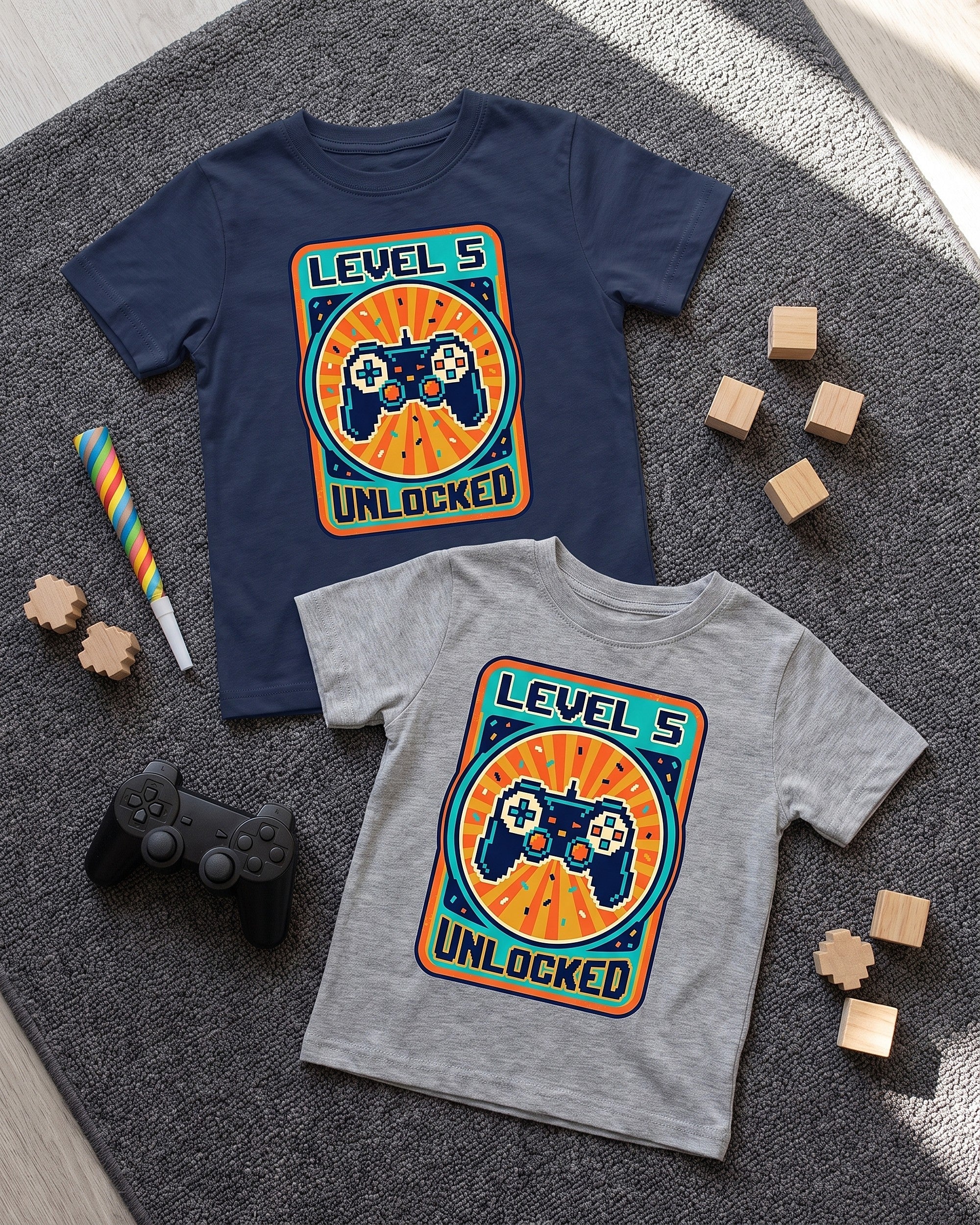 Flat lay of the Level 5 Unlocked arcade 5th birthday design across matching kids garments with playful props