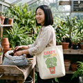 Crazy Plant Lady Canvas Tote Bag in natural, worn by an approved model, mid lifestyle photograph