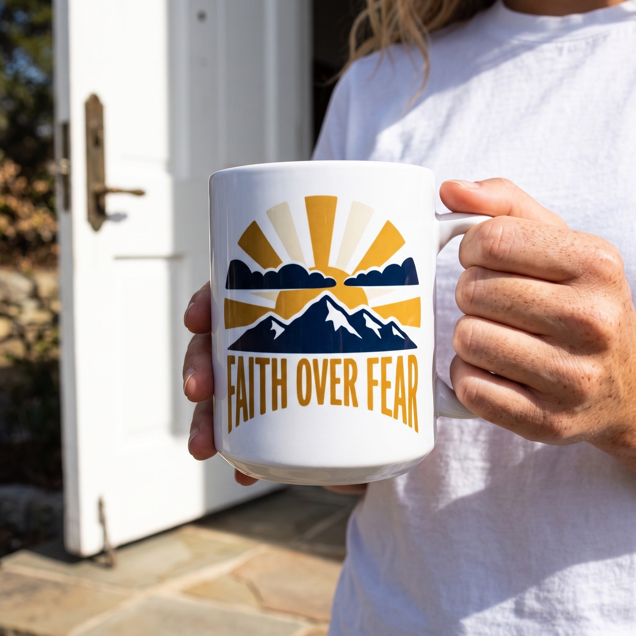 Faith Over Fear 11oz ceramic mug, held by an approved model, close lifestyle photograph