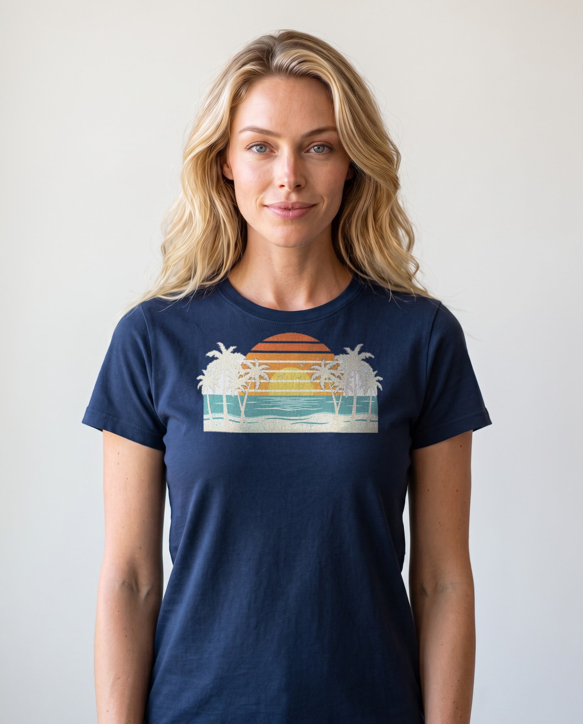 Woman wearing the Retro Beach Sunset tee in True Navy, cream palms and single striped sunset over ocean waves, corrected print