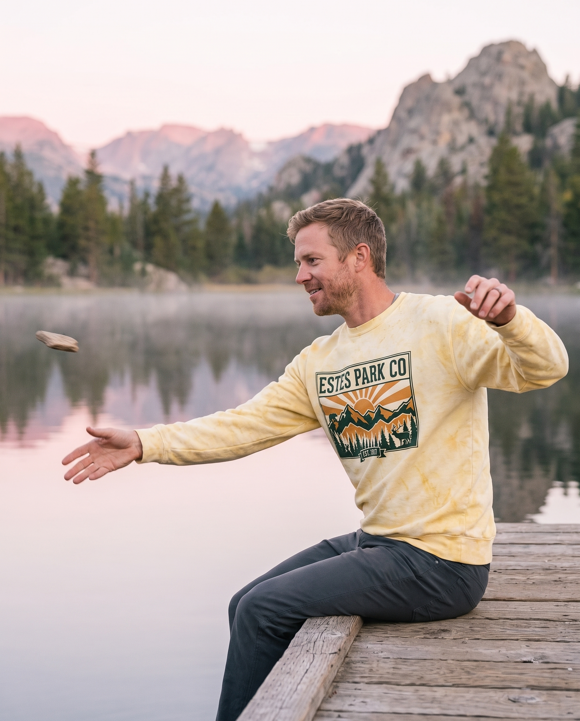 Man skipping stones from a lake dock at dawn in the citrine Estes Park CO hidden wildlife crewneck sweatshirt