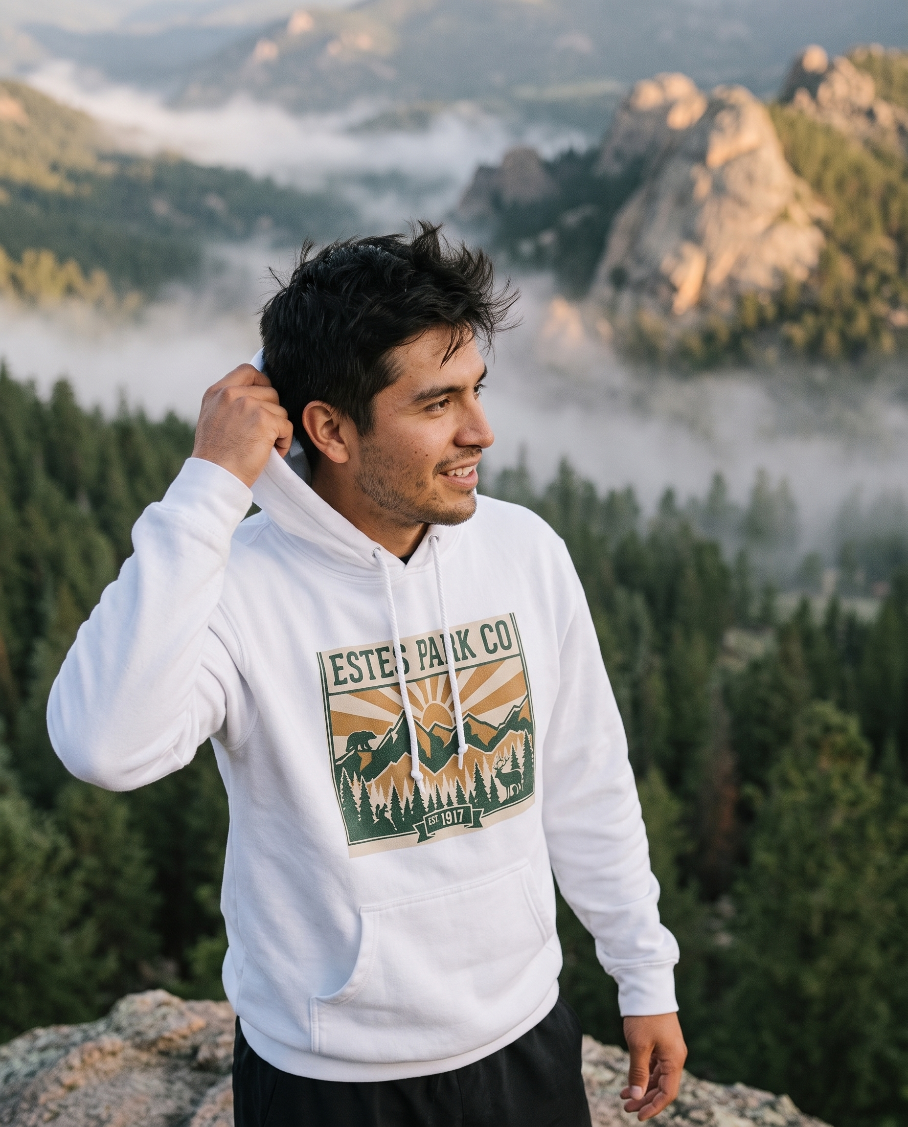 Man at a misty Rocky Mountain overlook wearing the white Estes Park CO hidden wildlife hoodie
