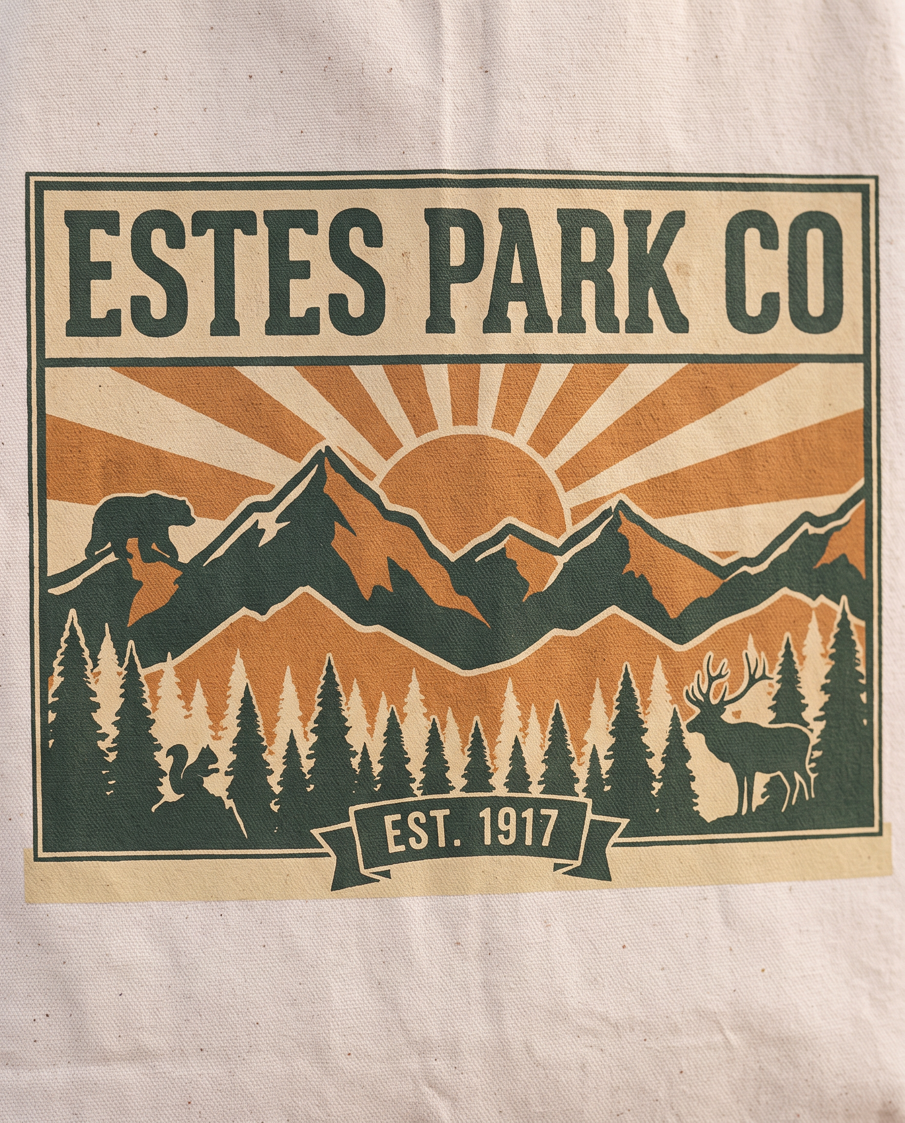 Estes Park CO hidden wildlife badge close-up on a natural canvas tote, bear elk and squirrel design, EST. 1917