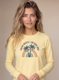Woman wearing the Palm Trees and 80 Degrees long sleeve tee in Butter, twin palms and 70s rainbow with PALM TREES AND 80 DEGREES text centered on the chest