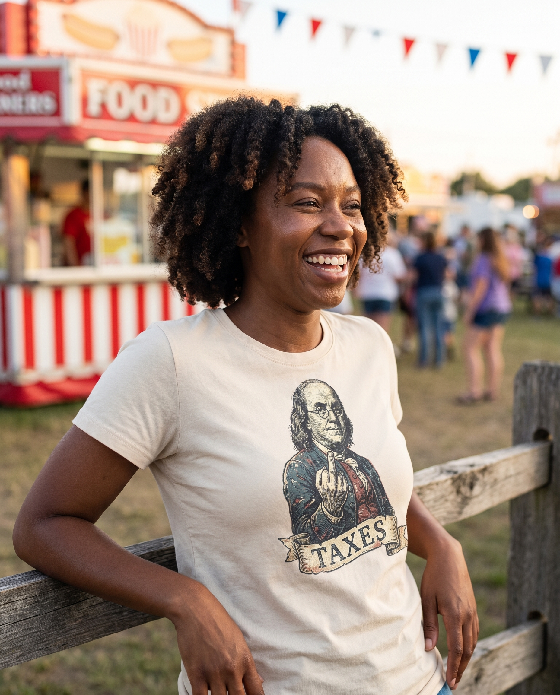 Woman leaning on a county fair fence in the Ben Franklin TAXES tee in Natural, vintage engraved Franklin print clearly visible, golden afternoon light