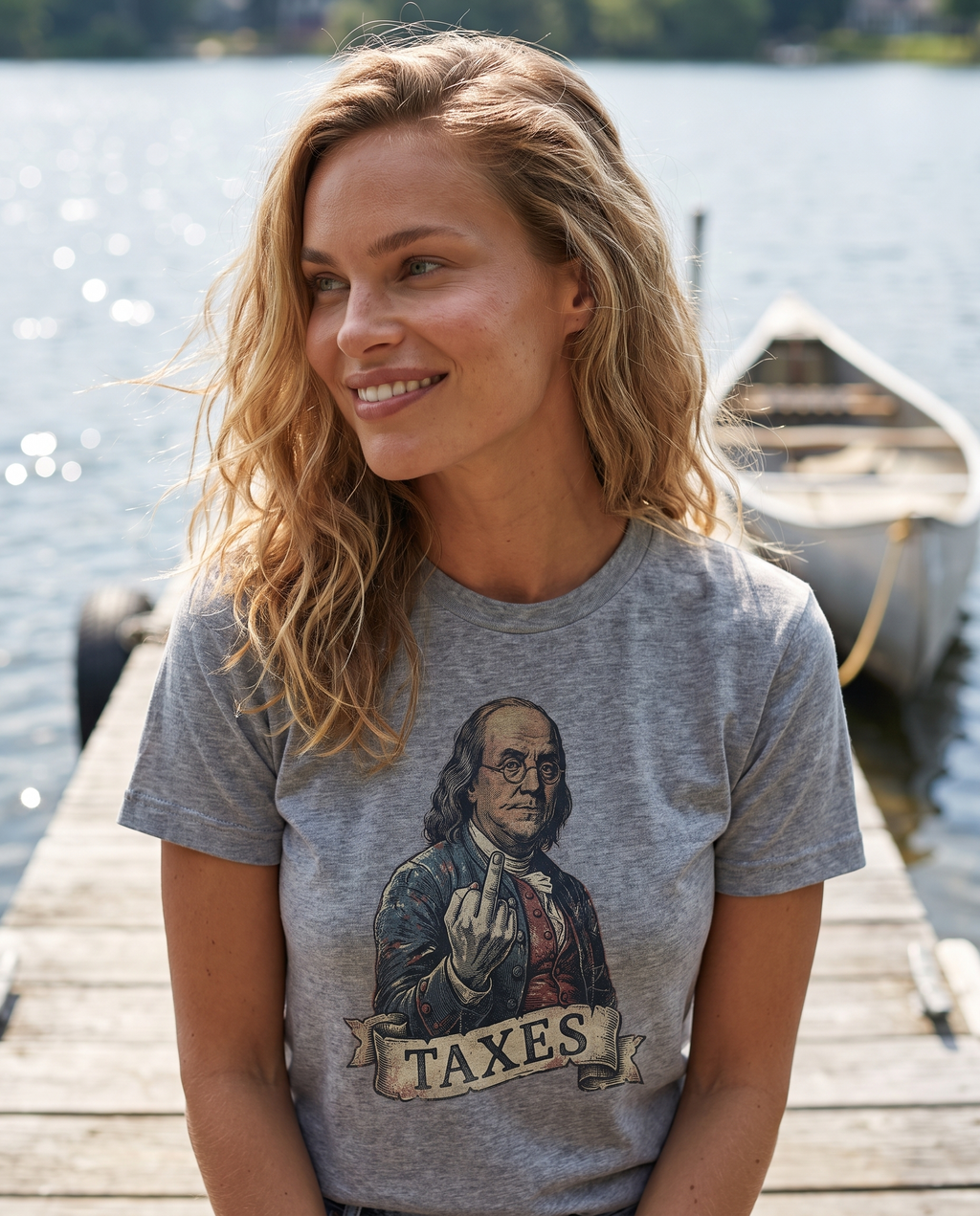 Woman on a summer lake dock in the Ben Franklin TAXES tee in Sport Grey, engraved Franklin print visible, canoe and water behind