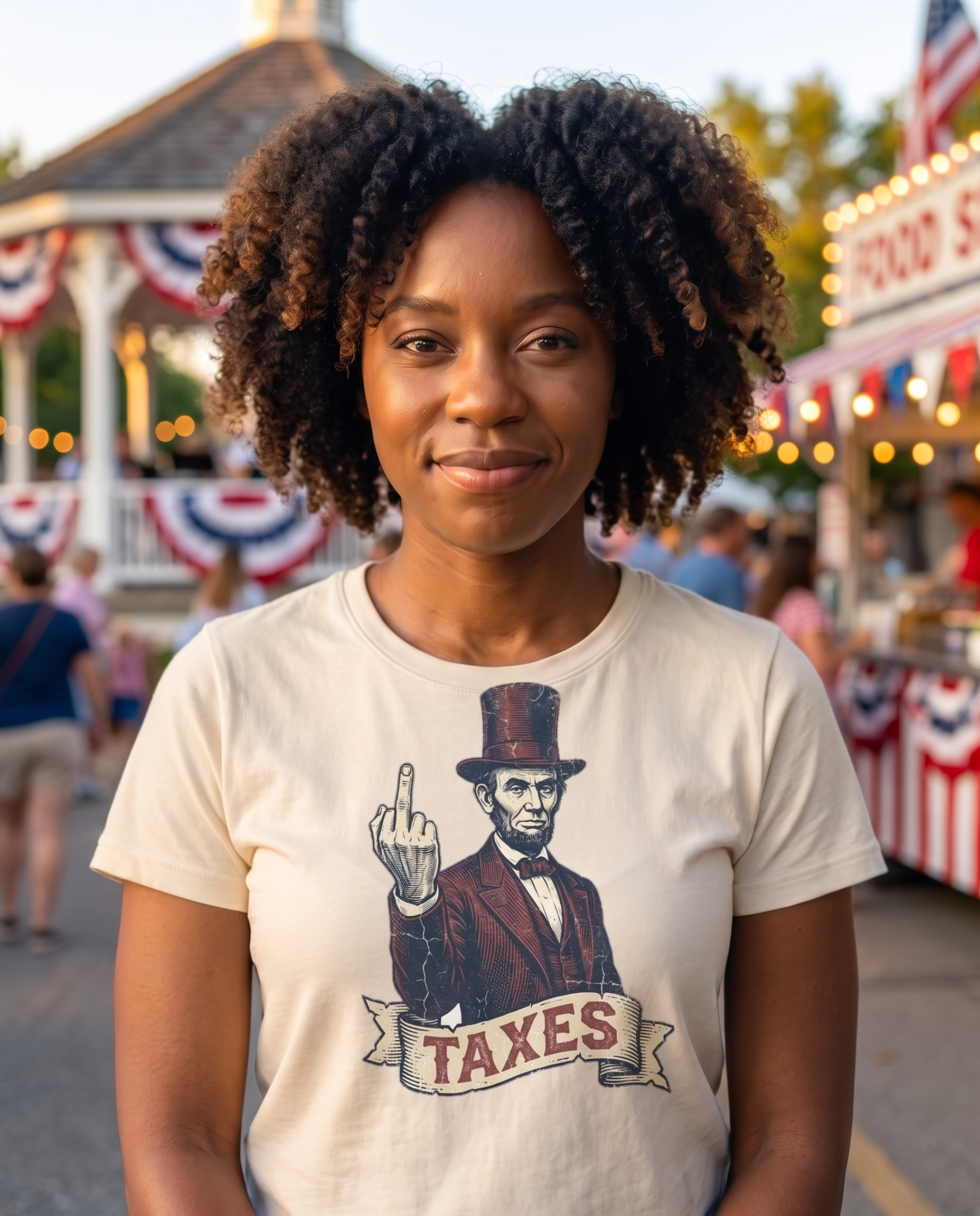 Woman at a small town July 4th street fair in the Abraham Lincoln TAXES tee in Natural, vintage engraved Lincoln print at mid chest, bunting and fair lights behind