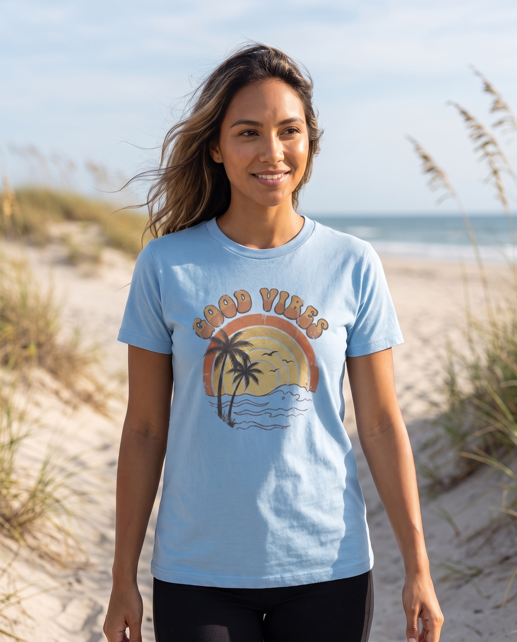 Good Vibes retro beach tee in Carolina blue on a dune path