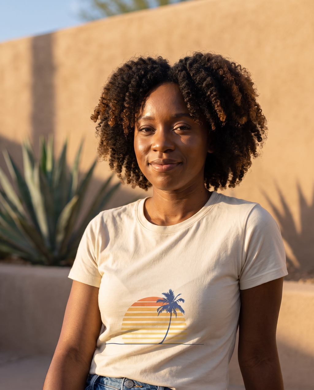 Retro palm and sunset minimalist tee in natural cream on a desert patio at golden hour