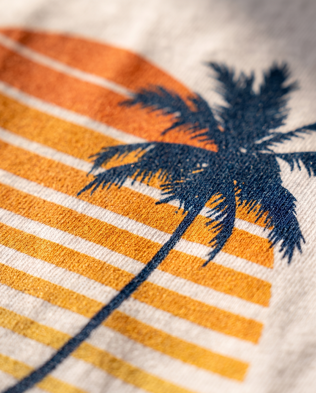 Close-up of the retro palm and sunset screen print on cotton