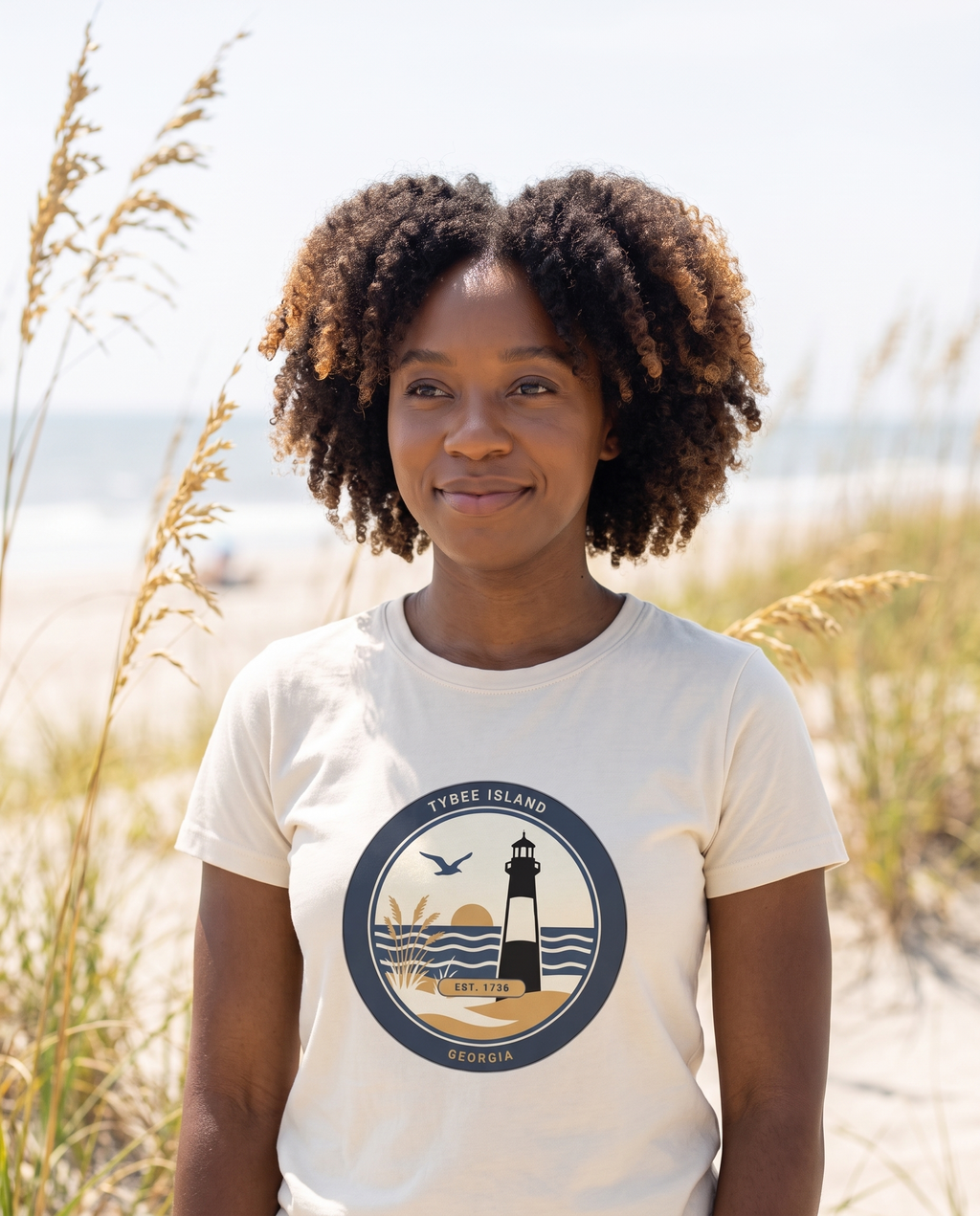 Woman wearing the Ivory Tybee Island lighthouse badge tee on the North Beach dunes
