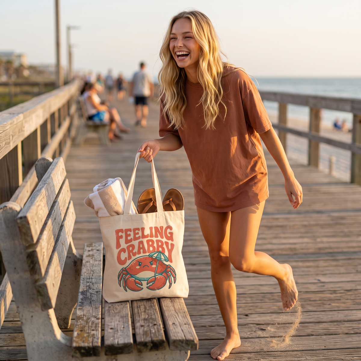Feeling Crabby canvas tote on a boardwalk bench with a towel and sandals