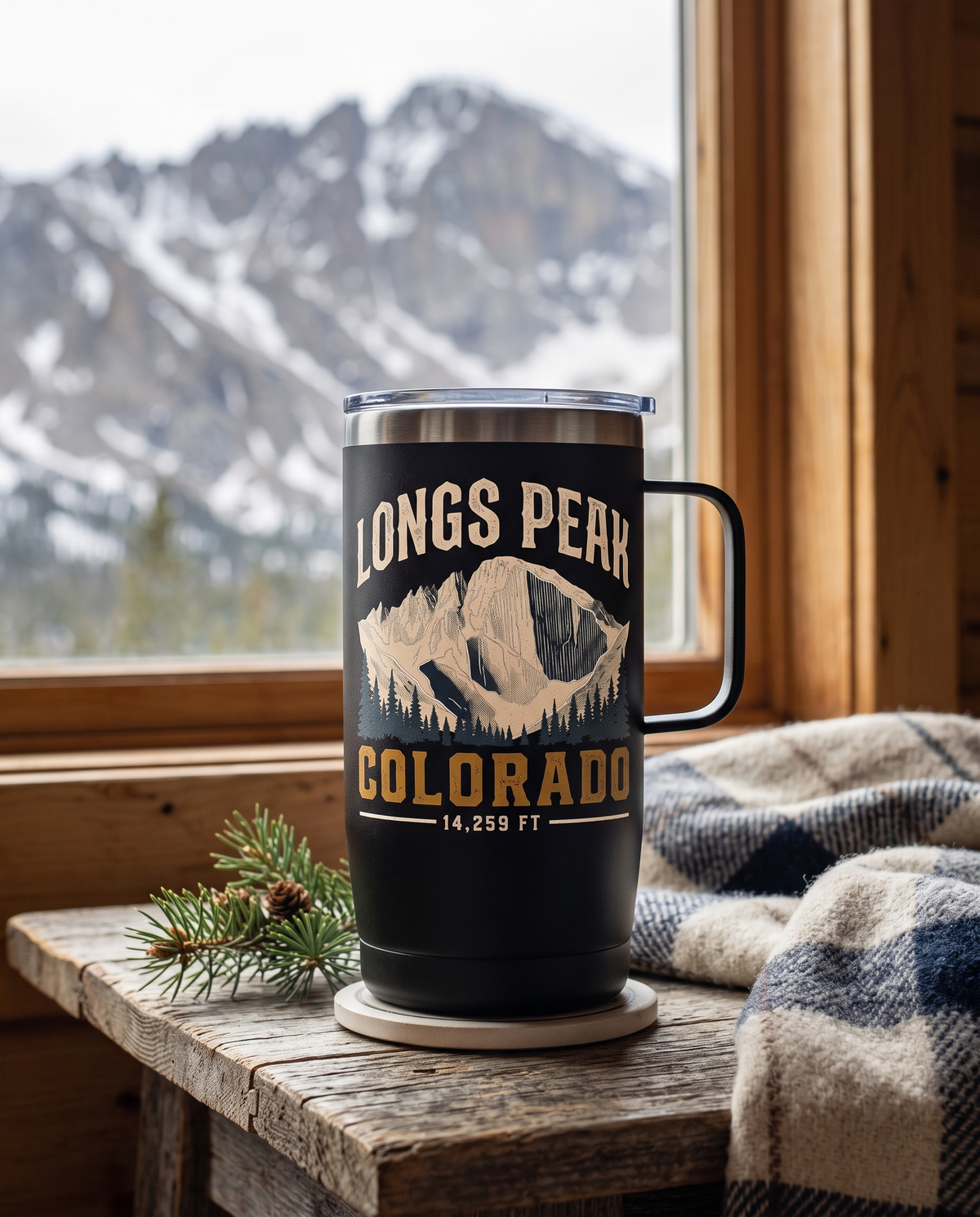 Longs Peak Colorado 15oz coffee tumbler in Black on a cabin table