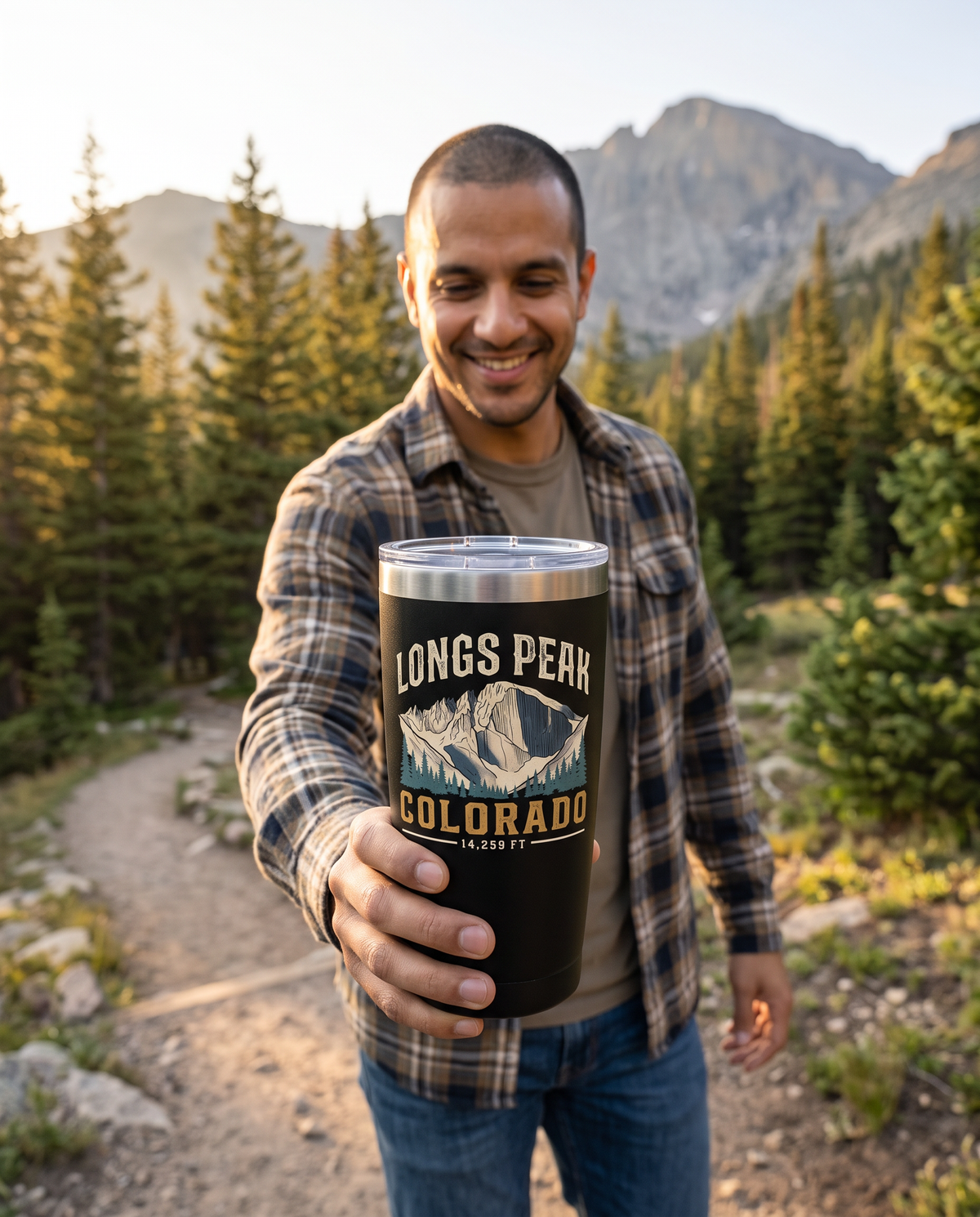 Hiker on a trail holding out a Black Longs Peak Colorado 20oz insulated tumbler, 14,259 FT, lifestyle photograph