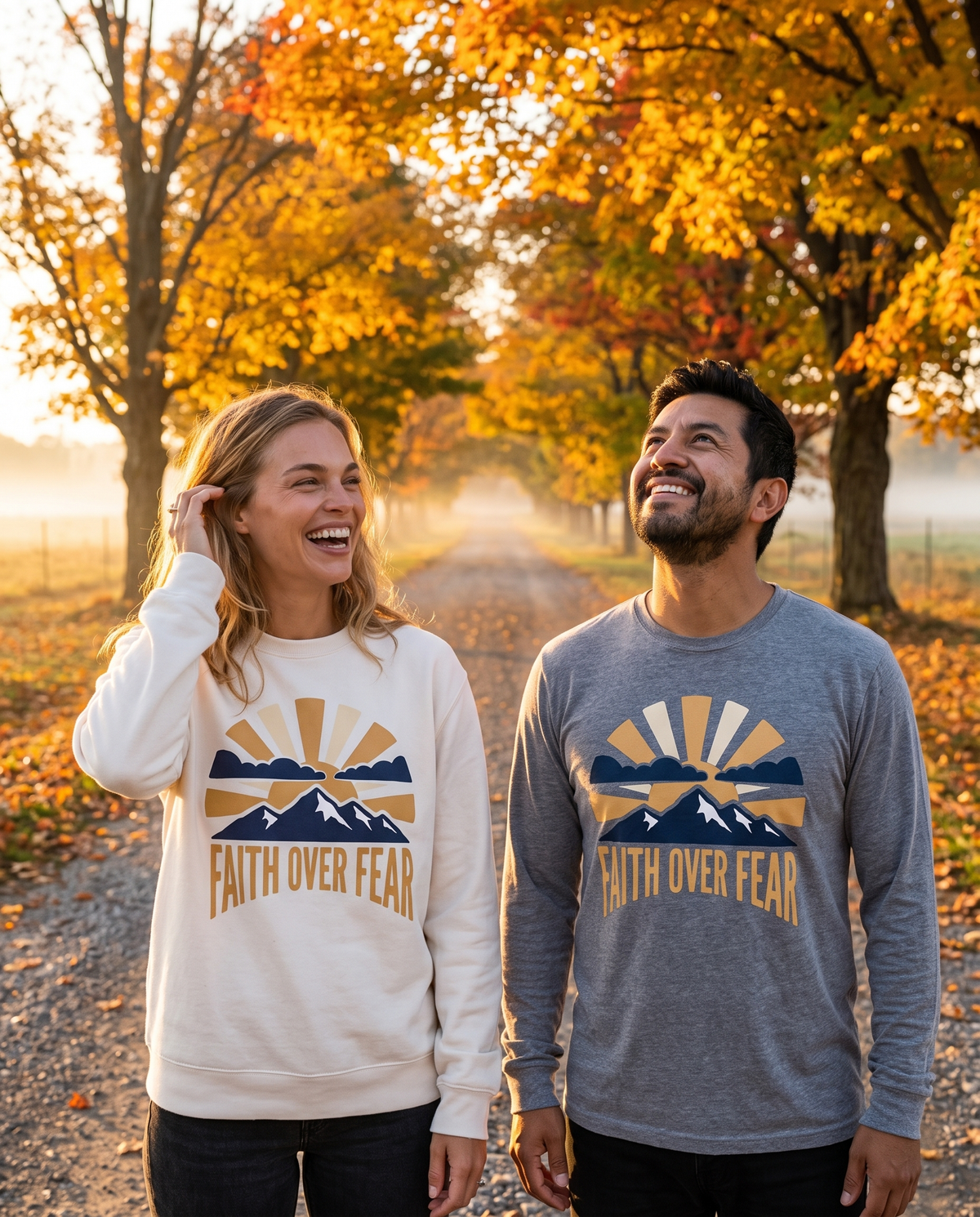 Couple on a tree-lined autumn road in a Faith Over Fear White crewneck and Grey long sleeve tee