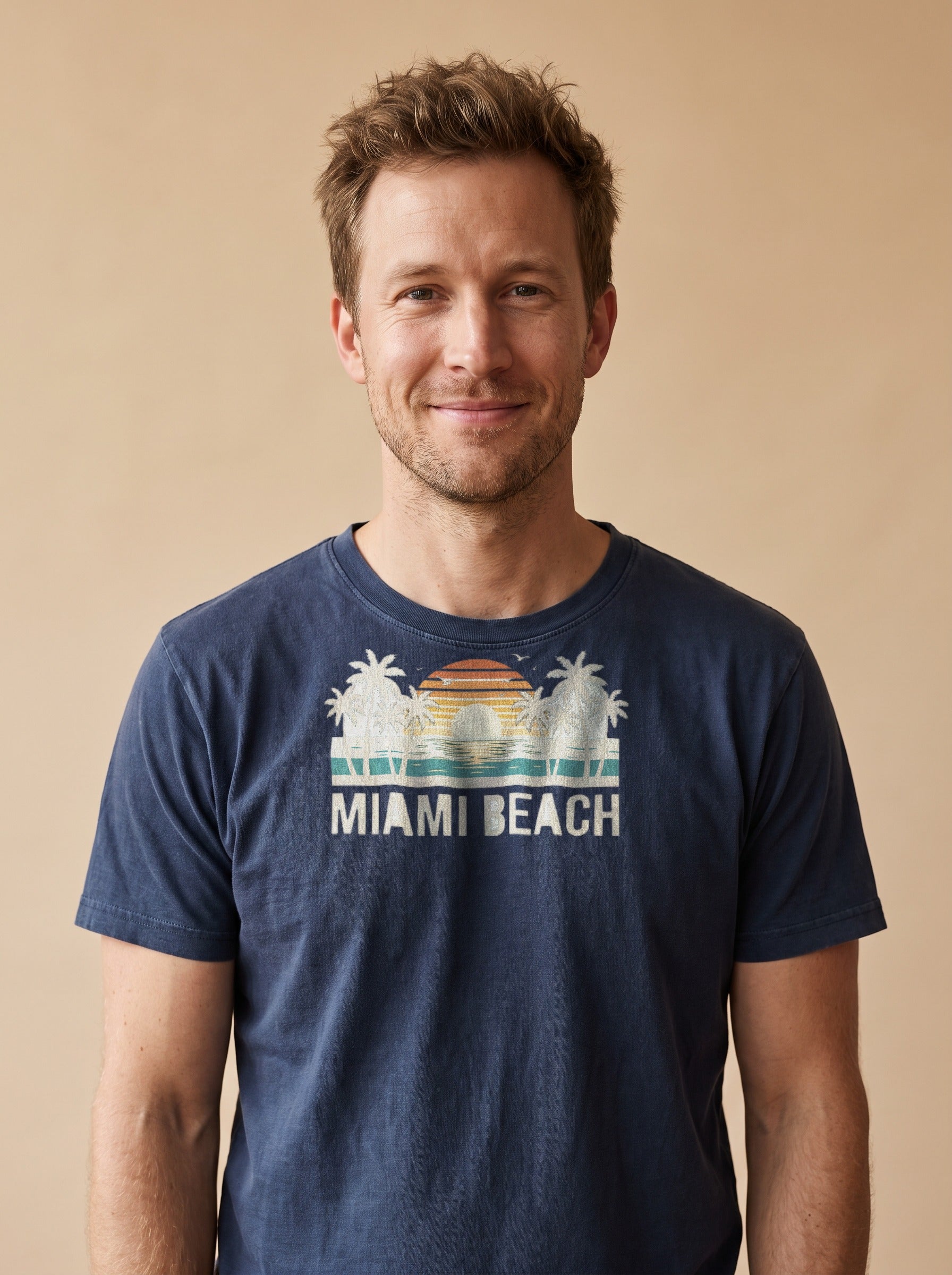 Man wearing the Miami Beach retro tee in Navy, cream palms and single striped sunset with Miami Beach lettering