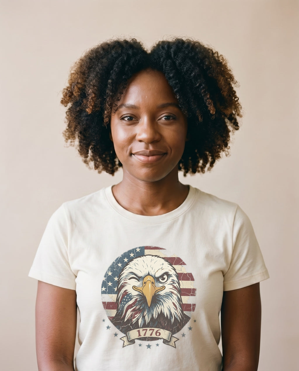 Woman wearing the Winking 1776 Eagle retro tee in Ivory, winking bald eagle over US flag circle badge