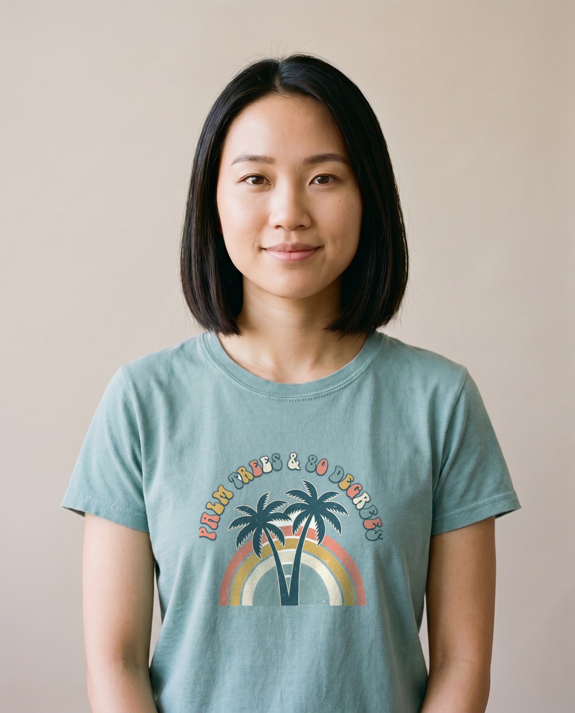 Palm Trees and 80 Degrees retro tee in Bay seafoam on a model, Comfort Colors garment-dyed, twin palms and 70s rainbow arch