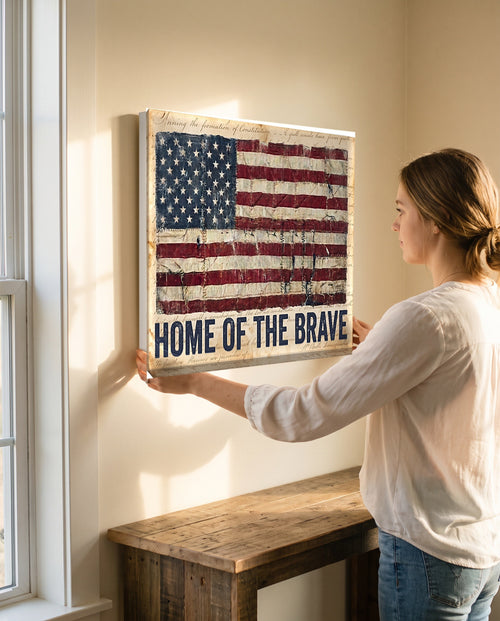 Woman leveling the Home of the Brave flag canvas, showing its true 24 by 18 inch size
